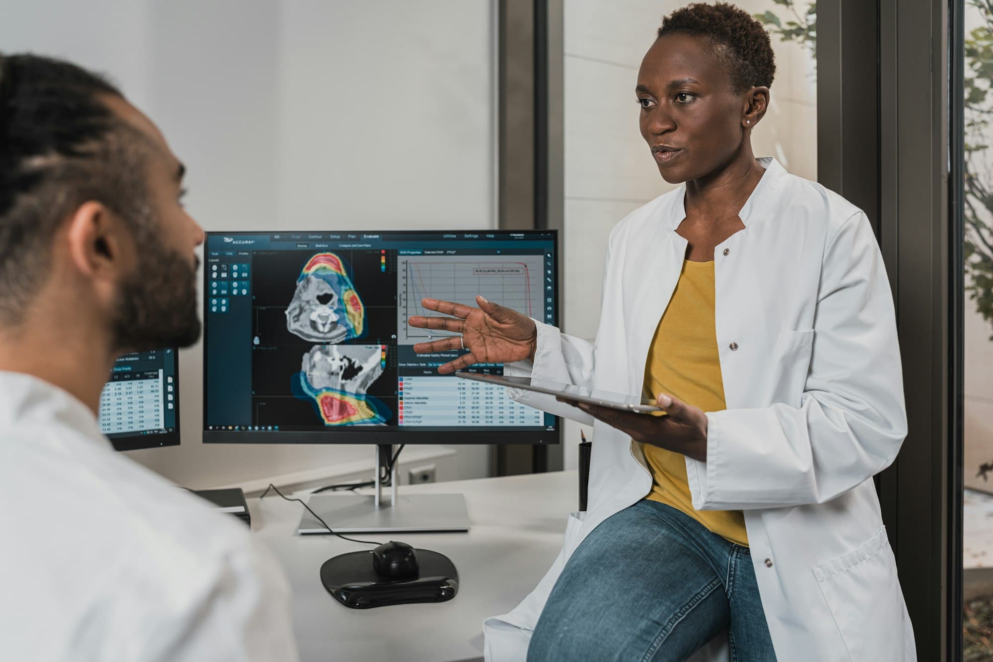 Two clinicians reviewing information together on a computer screen